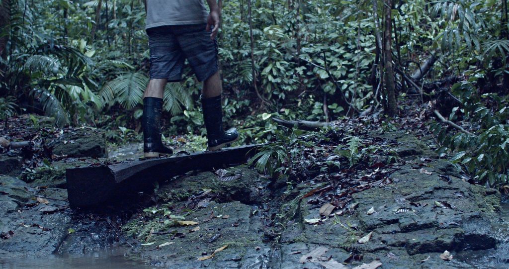 Muddy boots on a man walking through the jungle of the Indio Maiz.