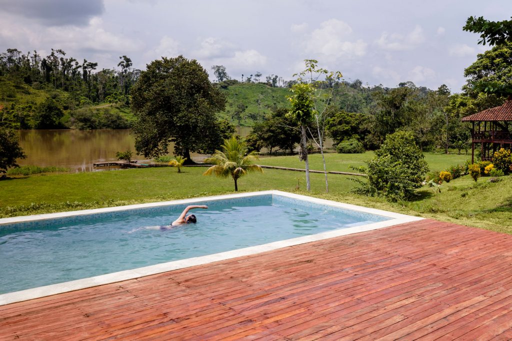 The swimming pool at Guacimo Lodge with one person swimming.
